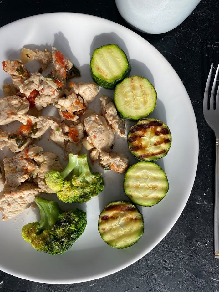 Delicious grilled chicken with zucchini and broccoli, beautifully plated for a nutritious meal.
